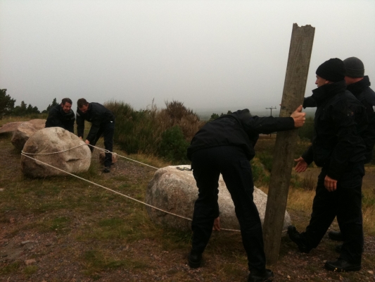 a team of people out in the hills, interacting in a team building exercise